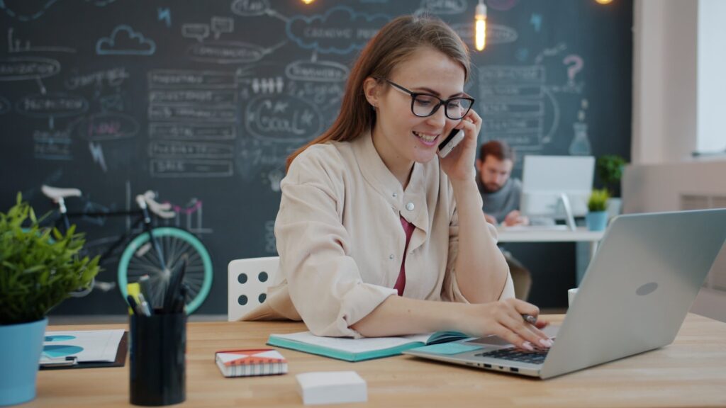 home care CRM for small agencies shown on a laptop while a small agency owner takes a call at her desk